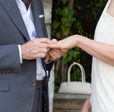 A groom placing a ring on the bride's finger during a wedding ceremony.