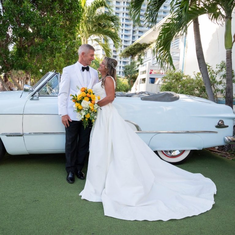 Ft. Lauderdale Wedding Bride and groom share a moment with a vintage car in a tropical setting.